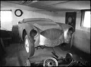 Black and white image of a car standing in garage