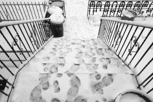 A black and white photo of a staircase covered in snow.
