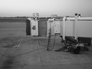 A black and white photo of an airplane parked on the tarmac.
