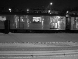 A black and white photo of a train in the snow.