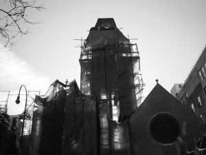 A black and white photo of a church with scaffolding.