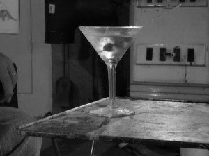 Black and white photo of a martini on a table.