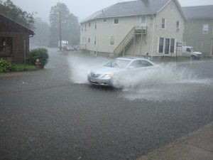 A car driving through a flooded street.