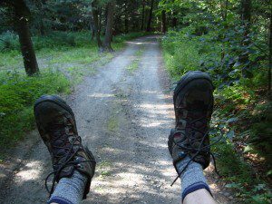 A person's feet on a dirt road.