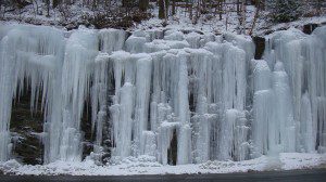 Icicles hanging from the side of a mountain.
