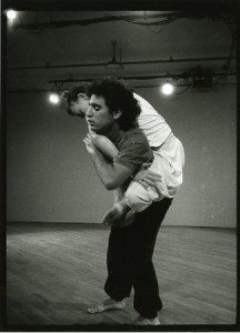 A black and white photo of two people in a dance studio.