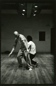 A black and white photo of two men in a dance studio.