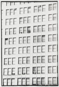 A black and white photo of a building with many windows.