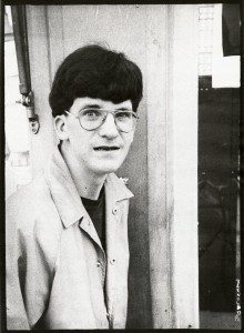 A young man wearing glasses and a jacket.