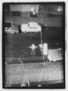 An old black and white photo of a man on a skateboard.