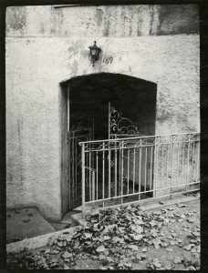 A black and white photo of a gated entrance.