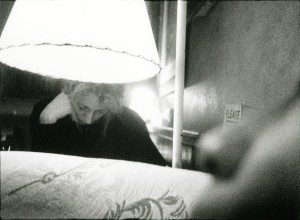 A black and white photo of a woman under a lamp.