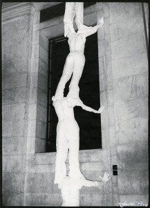 A black and white photo of a statue with two people on top of it.