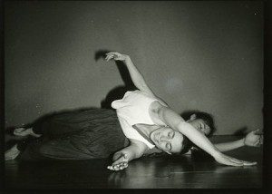 A black and white photo of two people laying on the floor.