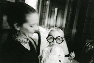 An old black and white photo of a woman with glasses and a child.