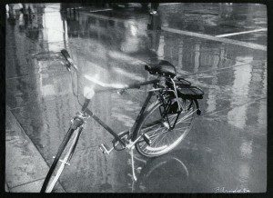 A black and white photo of a bicycle in the rain.