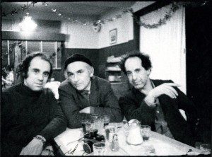 Three men posing for a photo at a table.