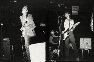 A black and white photo of a group of people playing guitars.