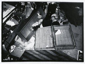 A black and white photo of a wicker basket on the floor.