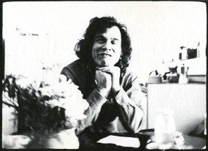 A black and white photo of a man sitting at a table.