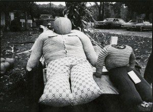 A black and white photo of two stuffed animals sitting on a bench.