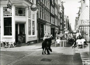 An old black and white photo of a couple dancing on a street.