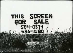 A black and white photo of a sign that says this screen for sale.
