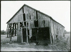 An old black and white photo of an old barn.