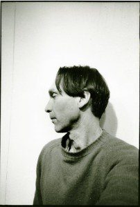 A black and white photo of a man in a sweater.