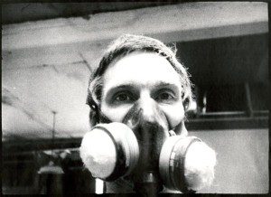 A man wearing a gas mask in a room.