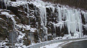 Icicles hanging from the side of a cliff.