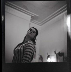 A black and white photo of a woman standing in a room.