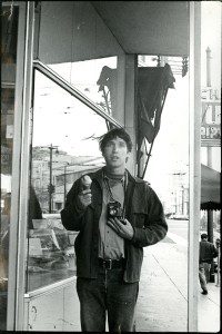 A man holding a camera in front of a store.