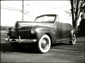 Black and white image of a car standing on the street