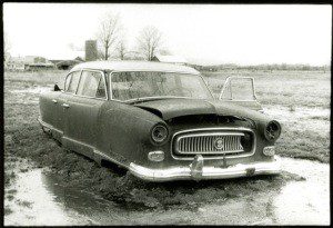 Black and white image of a car stuck in mud