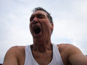 A man in a tank top with his mouth open.